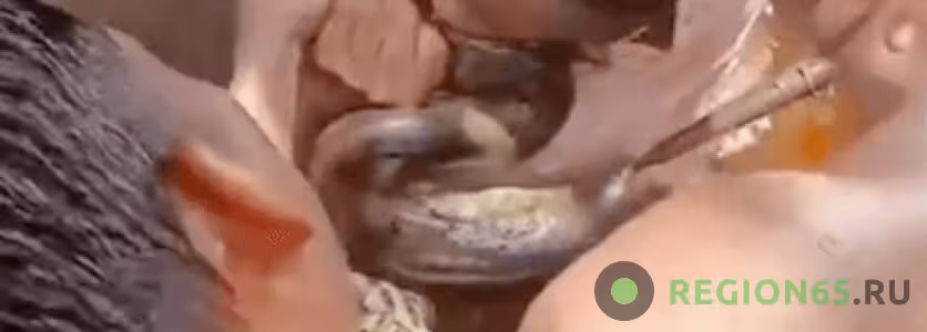 Мужчина кусает анаконду